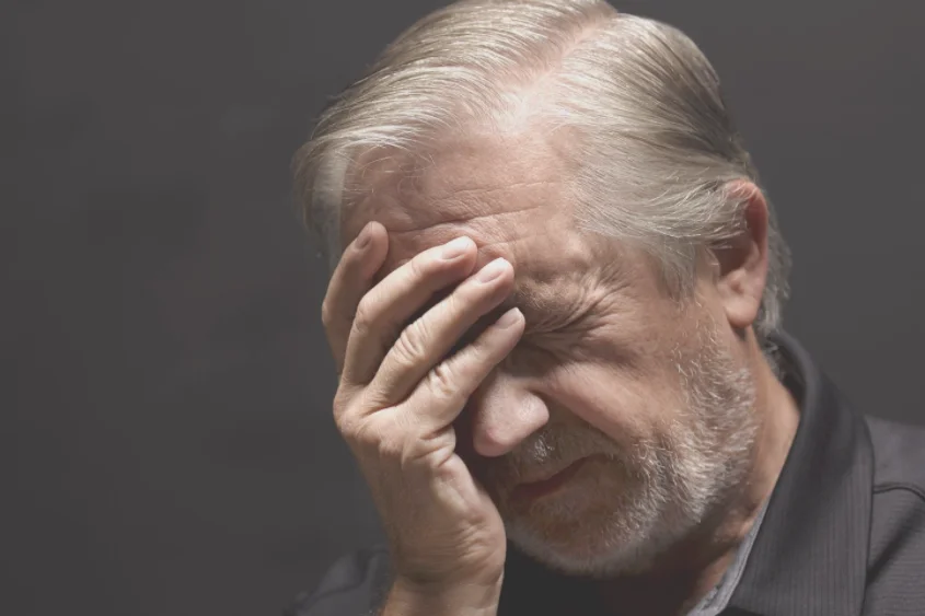 Stressed Man Holding Forehead - Brain Fog Supplements